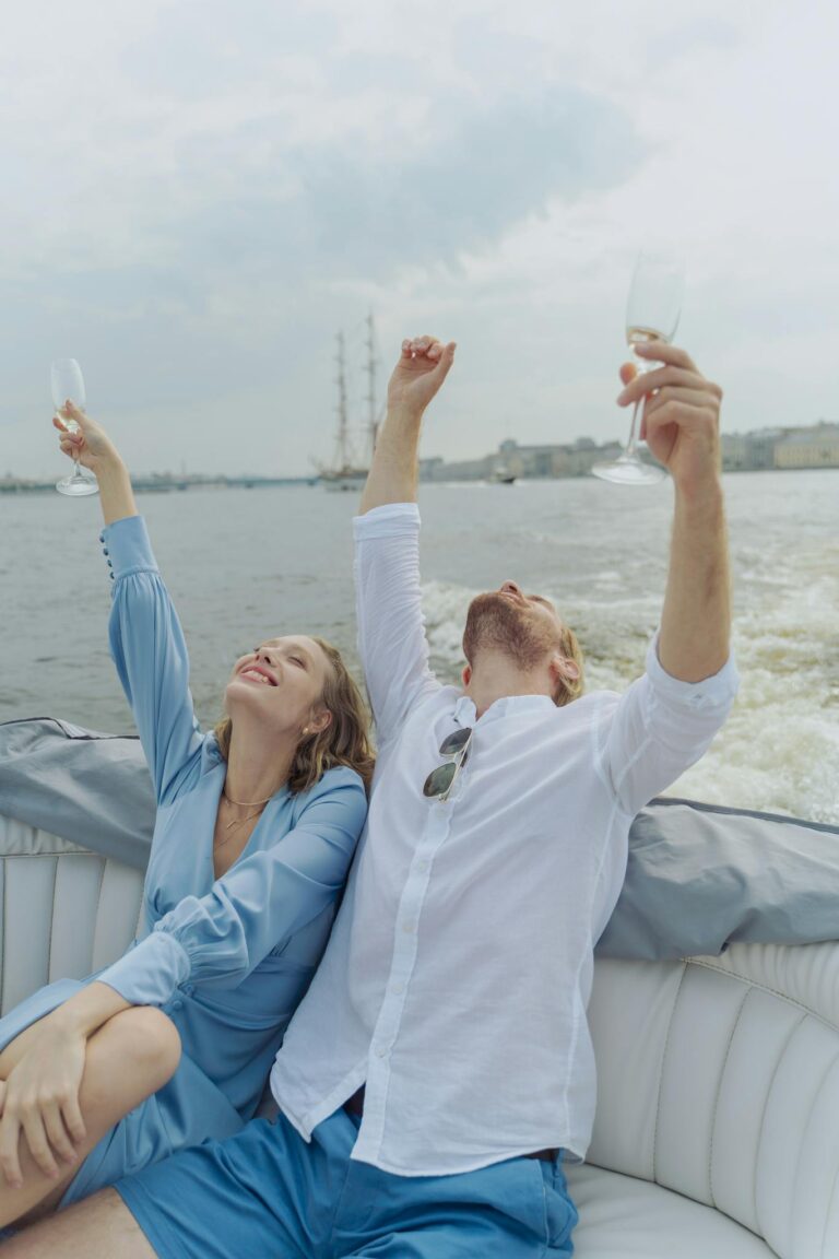 Happy couple toasting champagne glasses during a relaxing boat trip.